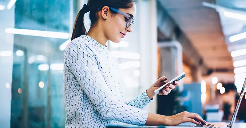 Woman working on computer and texting