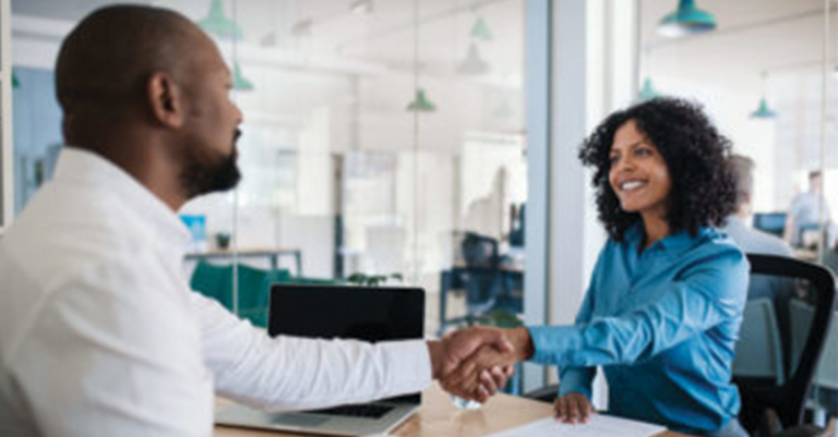 Smiling,African,American,Manager,Sitting,At,His,Desk,In,An,office